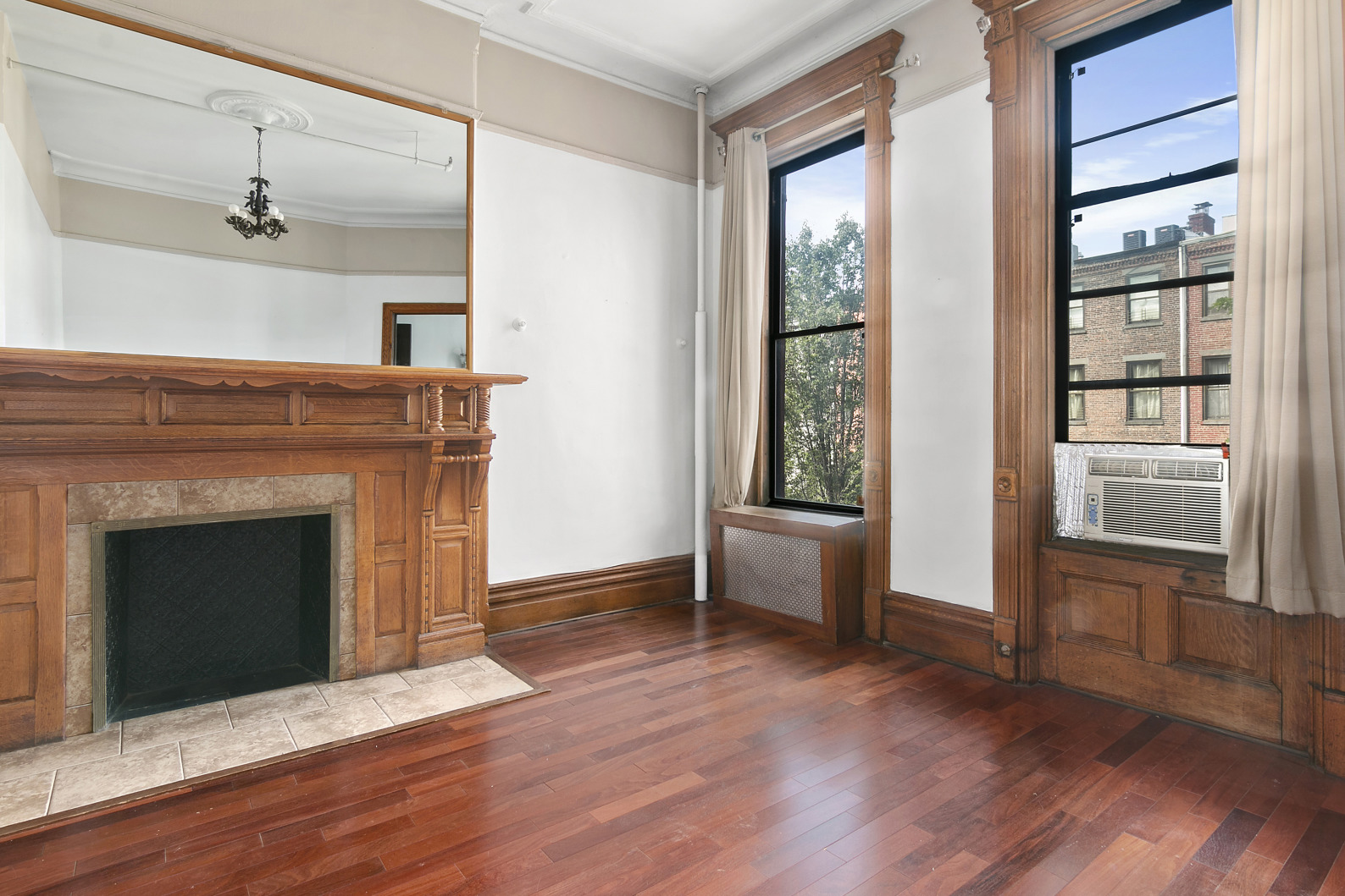 7 West 122nd Street, Unit 3 Manhattan, NY 10027 - Photo 3 of 6 a view of an empty room with wooden floor and a window