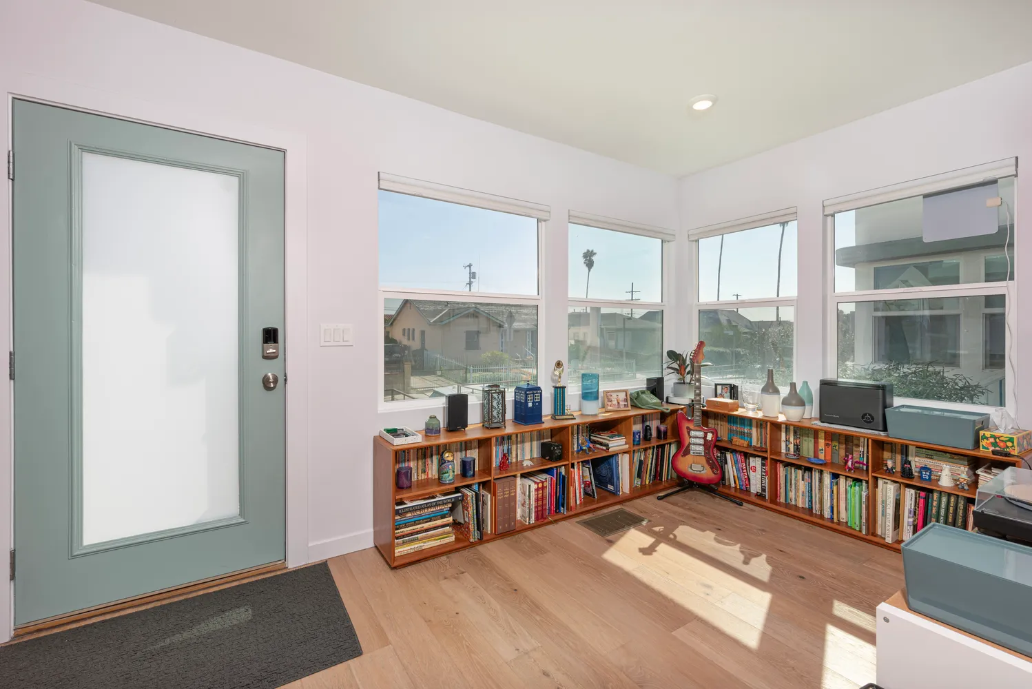 a large living room with stainless steel appliances wooden floor and a window