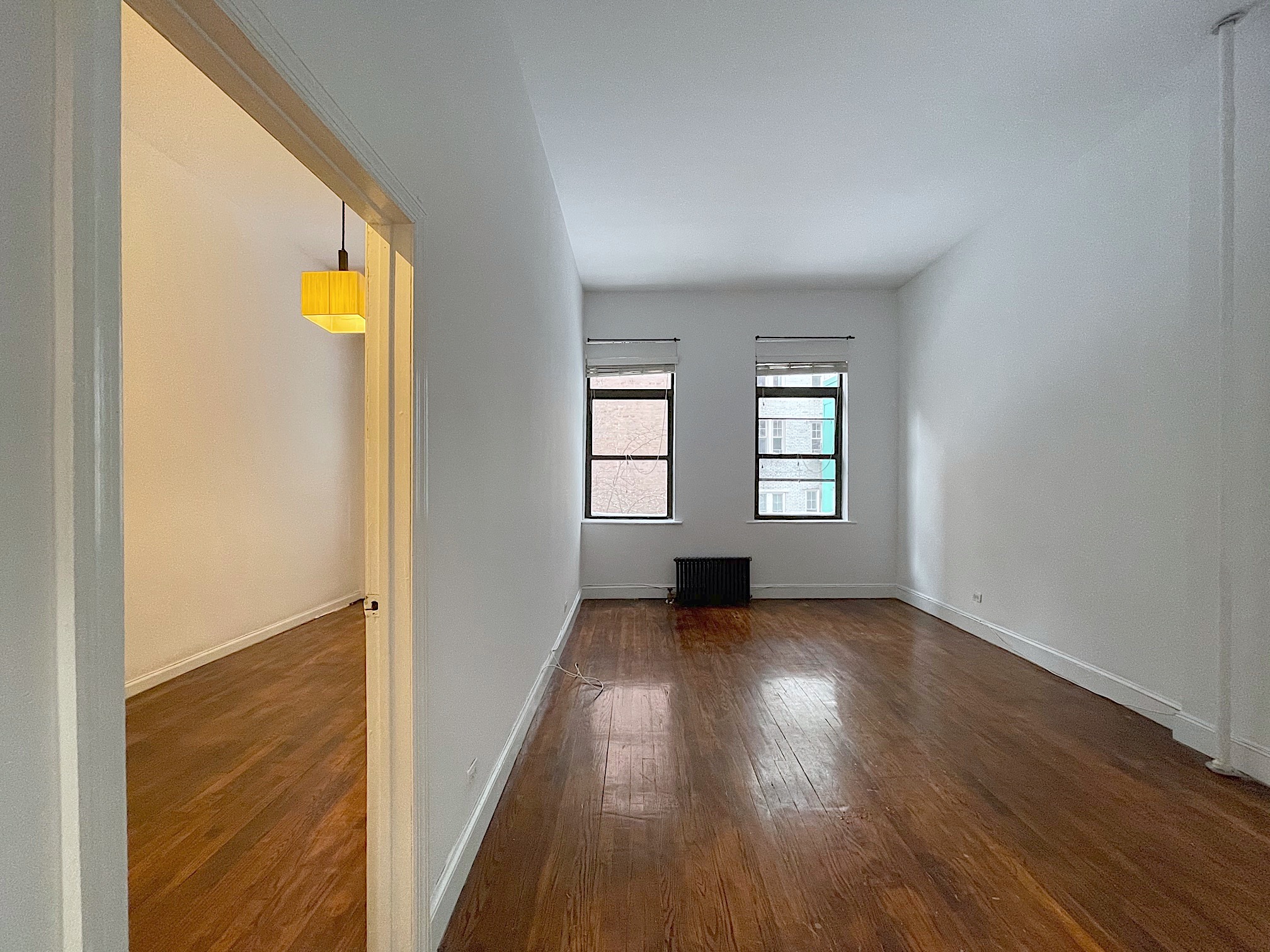 54 Jane Street Manhattan, NY 10014 - Photo 12 of 26 an empty room with wooden floor and windows