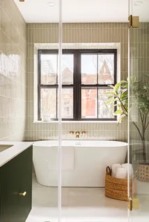 a bathroom with a bathtub and next to a window