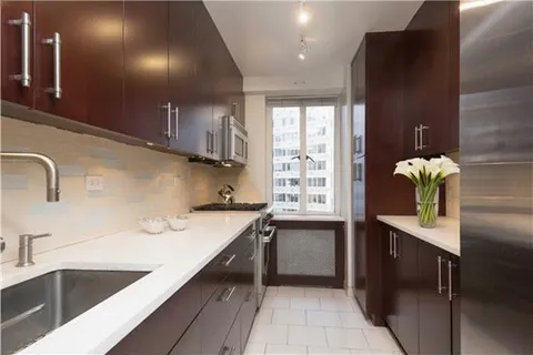 a kitchen with a sink cabinets and window