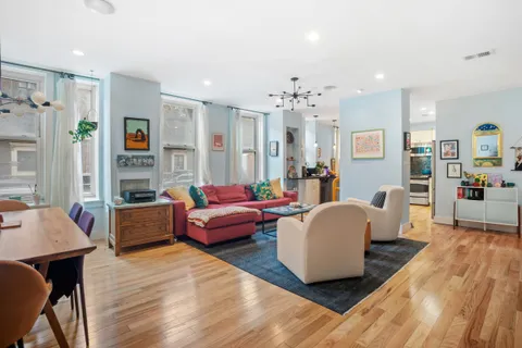 a living room with fireplace furniture and a wooden floor
