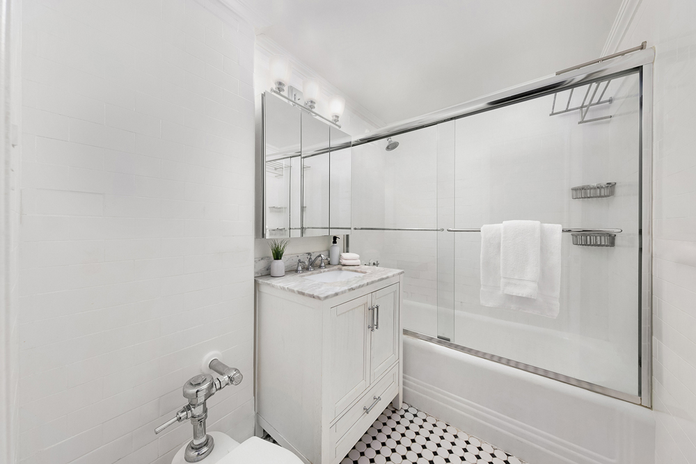 353 West 56th Street, Unit 2G Manhattan, NY 10019 - Photo 6 of 13 a bathroom with a sink a toilet and shower