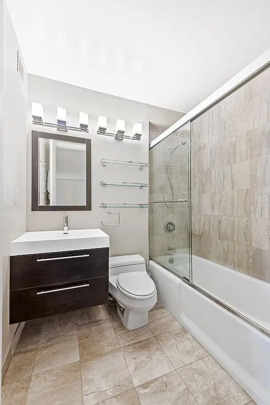 350 West 50th Street, Unit 15F Manhattan, NY 10019 - Photo 6 of 7 a bathroom with a sink a toilet and shower