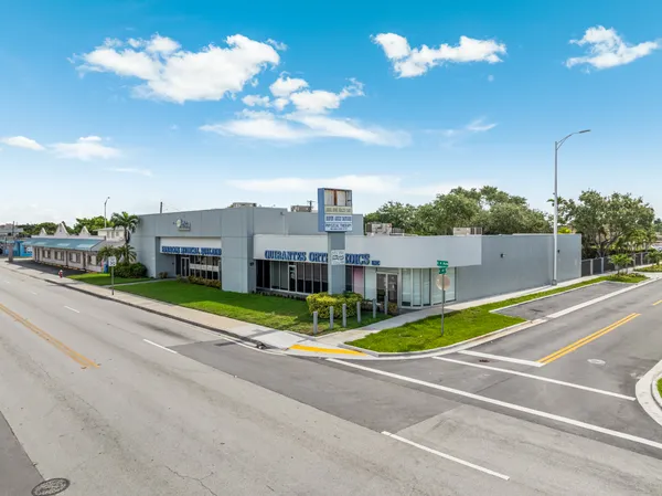 a view of a house with a big yard and large trees