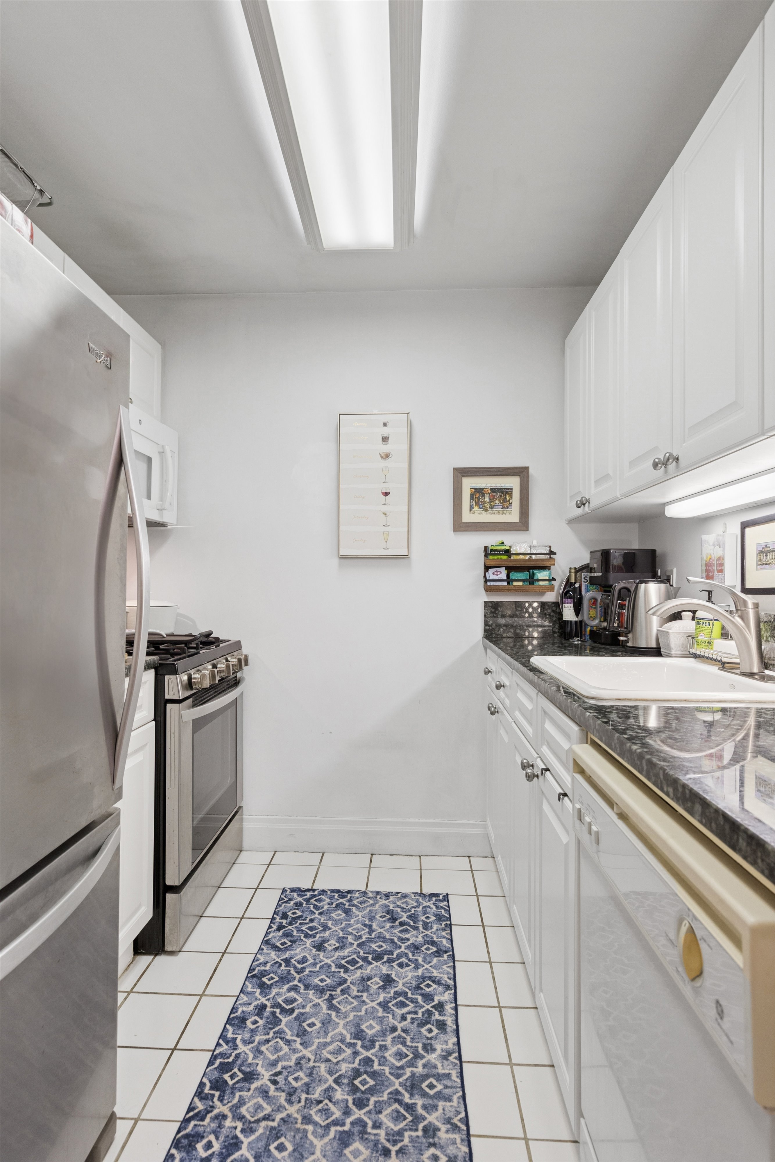 404 East 76th Street, Unit 4M Manhattan, NY 10021 - Photo 3 of 13 a kitchen with stainless steel appliances granite countertop a refrigerator and a stove top oven