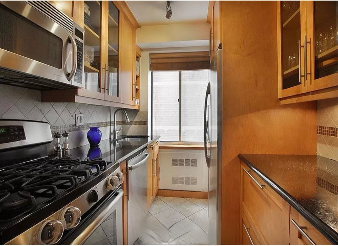 420 East 58th Street, Unit 17B Manhattan, NY 10022 - Photo 5 of 12 a kitchen with stainless steel appliances granite countertop a stove and a refrigerator
