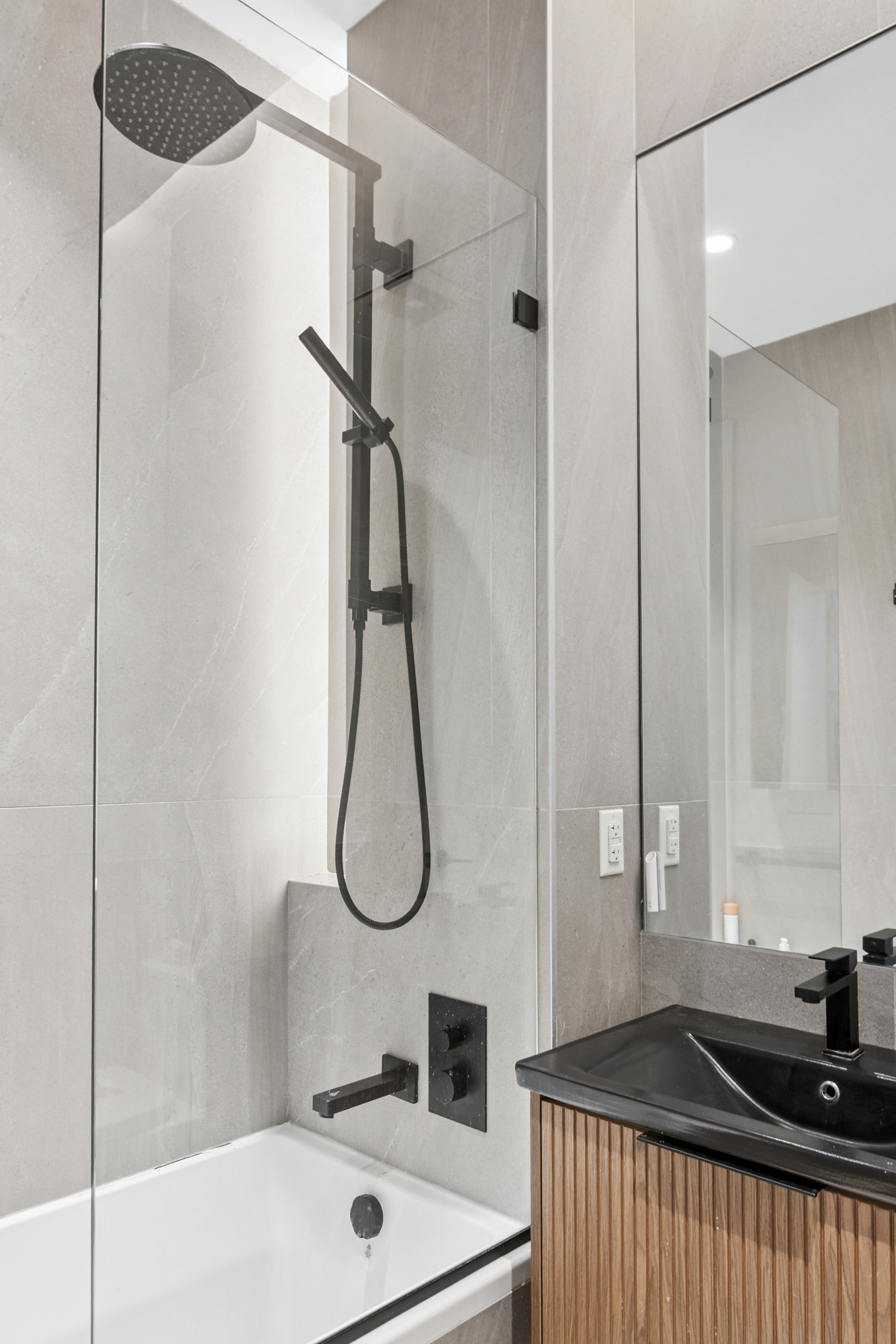 10 Quincy Street, Unit 1H Brooklyn, NY 11238 - Photo 6 of 15 a bathroom with a sink a mirror and a shower