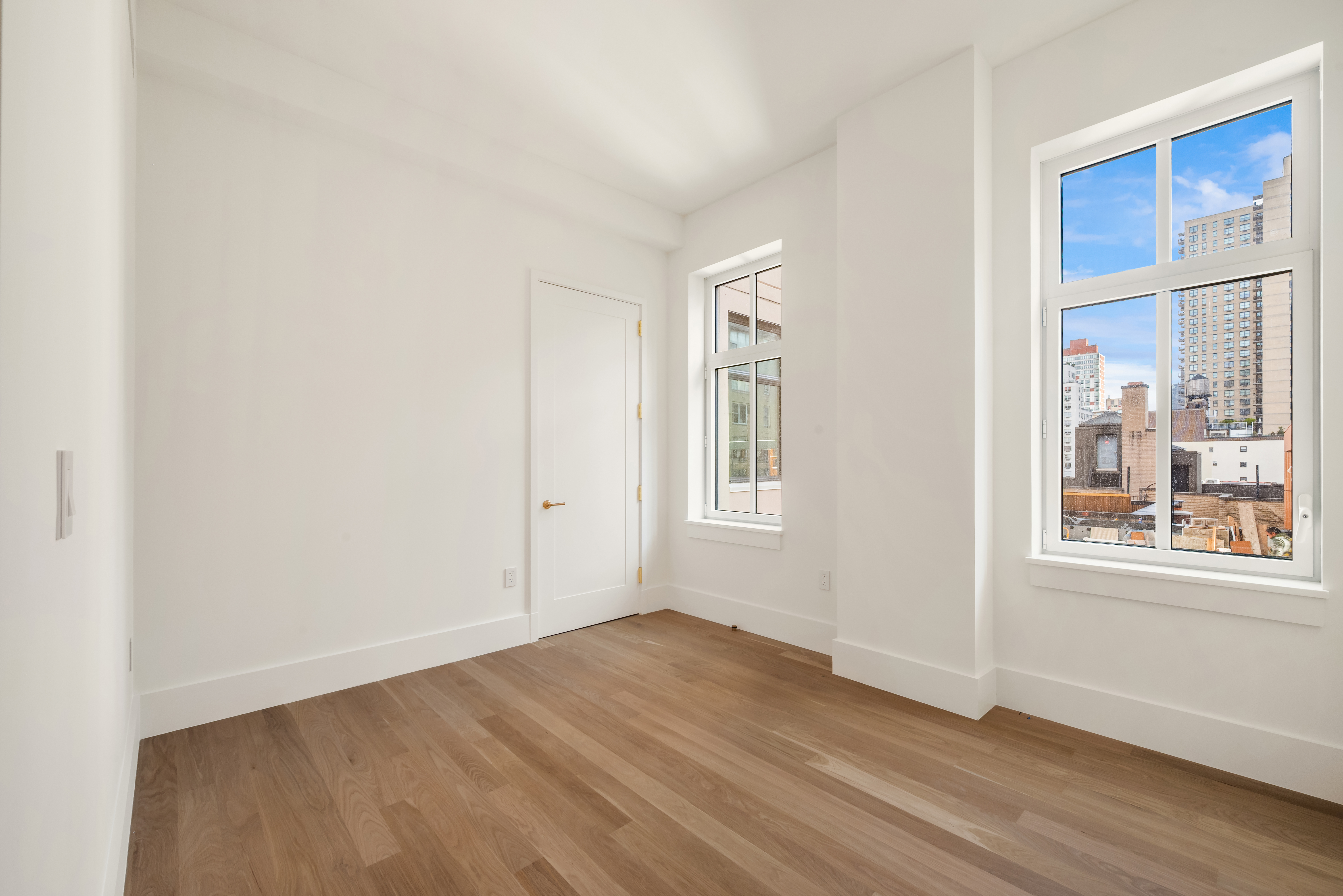 200 East 75th Street, Unit 6C Manhattan, NY 10021 - Photo 6 of 11 an empty room with wooden floor and windows