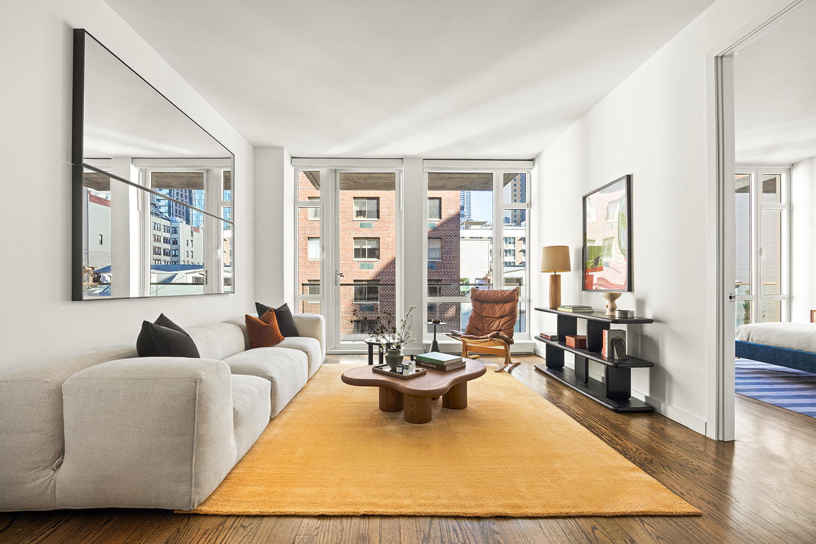 133 West 22nd Street, Unit 8G Manhattan, NY 10011 - Photo 1 of 16 a living room with furniture large window and a table