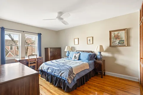 a bedroom with a bed a table and painting on the wall