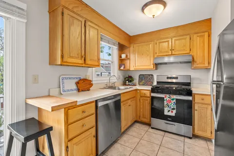 a kitchen with stainless steel appliances granite countertop a stove a sink and a refrigerator