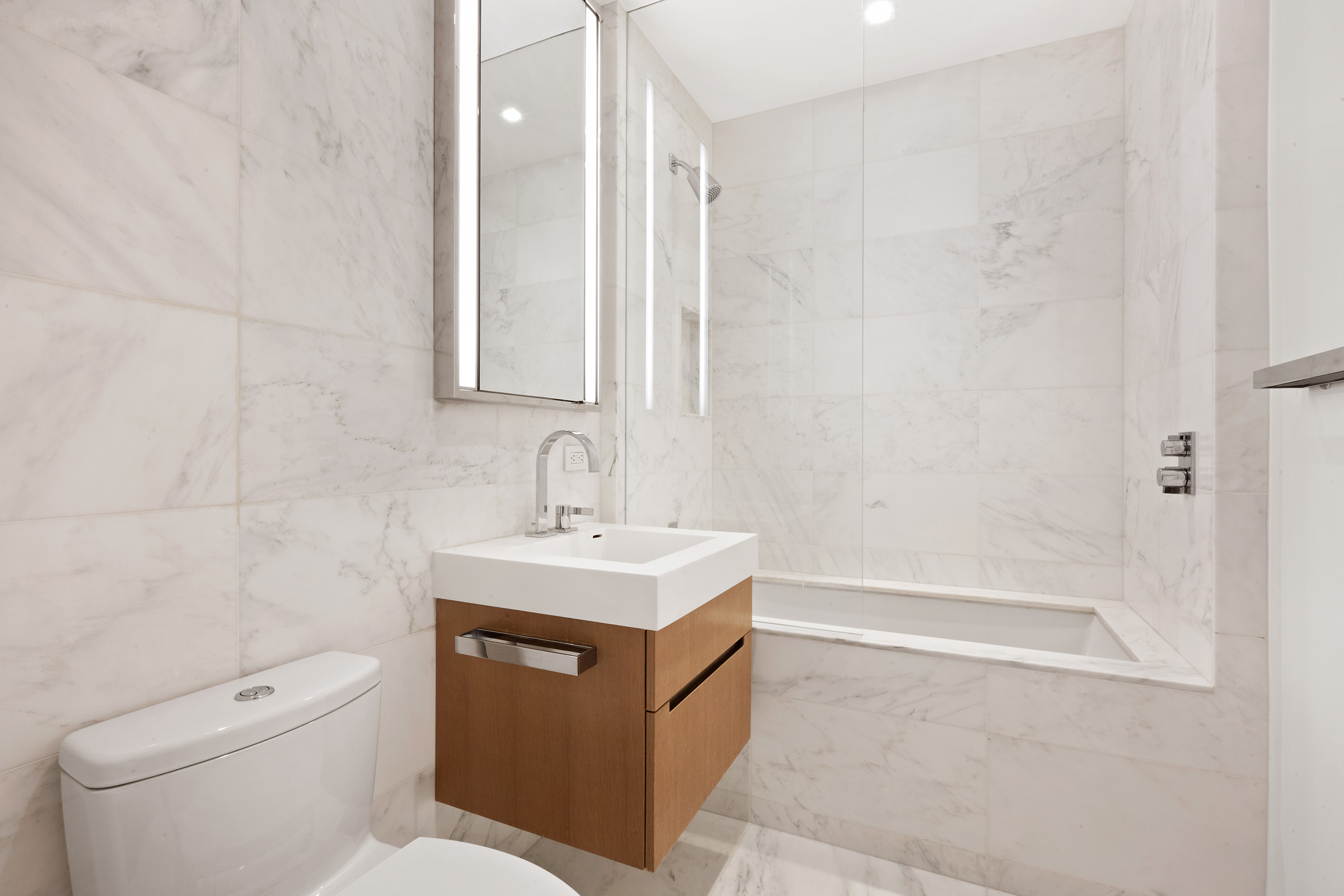 1 West End Avenue, Unit 14G Manhattan, NY 10023 - Photo 7 of 27 a bathroom with a sink a toilet and shower