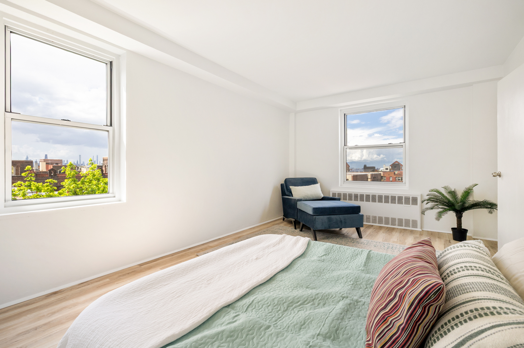 35-50 85th Street, Unit 9E Queens, NY 11372 - Photo 9 of 13 a living room with furniture and a potted plant