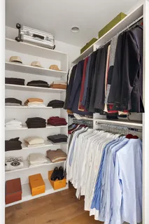 a view of walk in closet with clothes and shoes