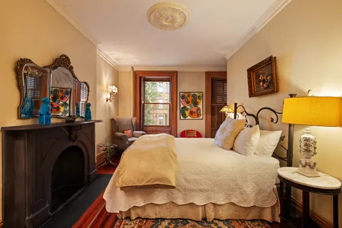 a bedroom with bed and a fireplace