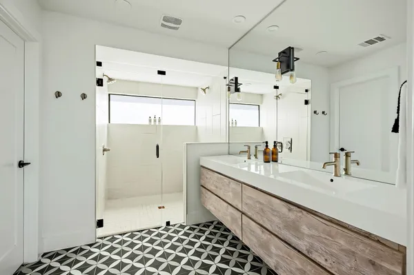 a bathroom with a double vanity sink mirror and shower