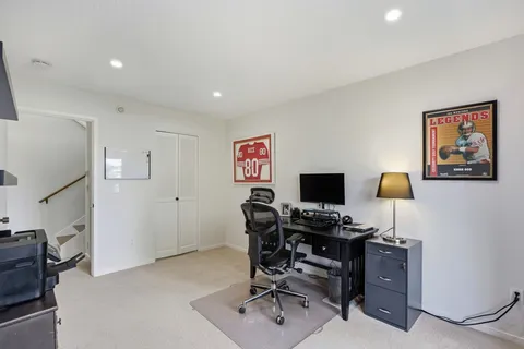 a view of a workspace with furniture and a window
