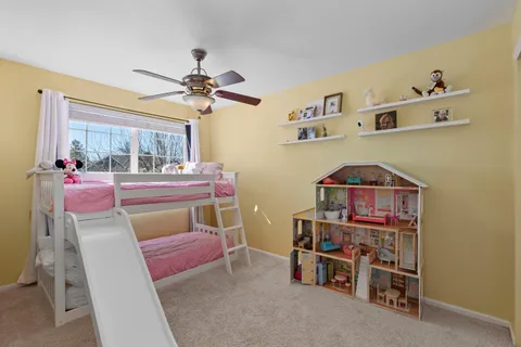a room with furniture a chandelier fan and a window