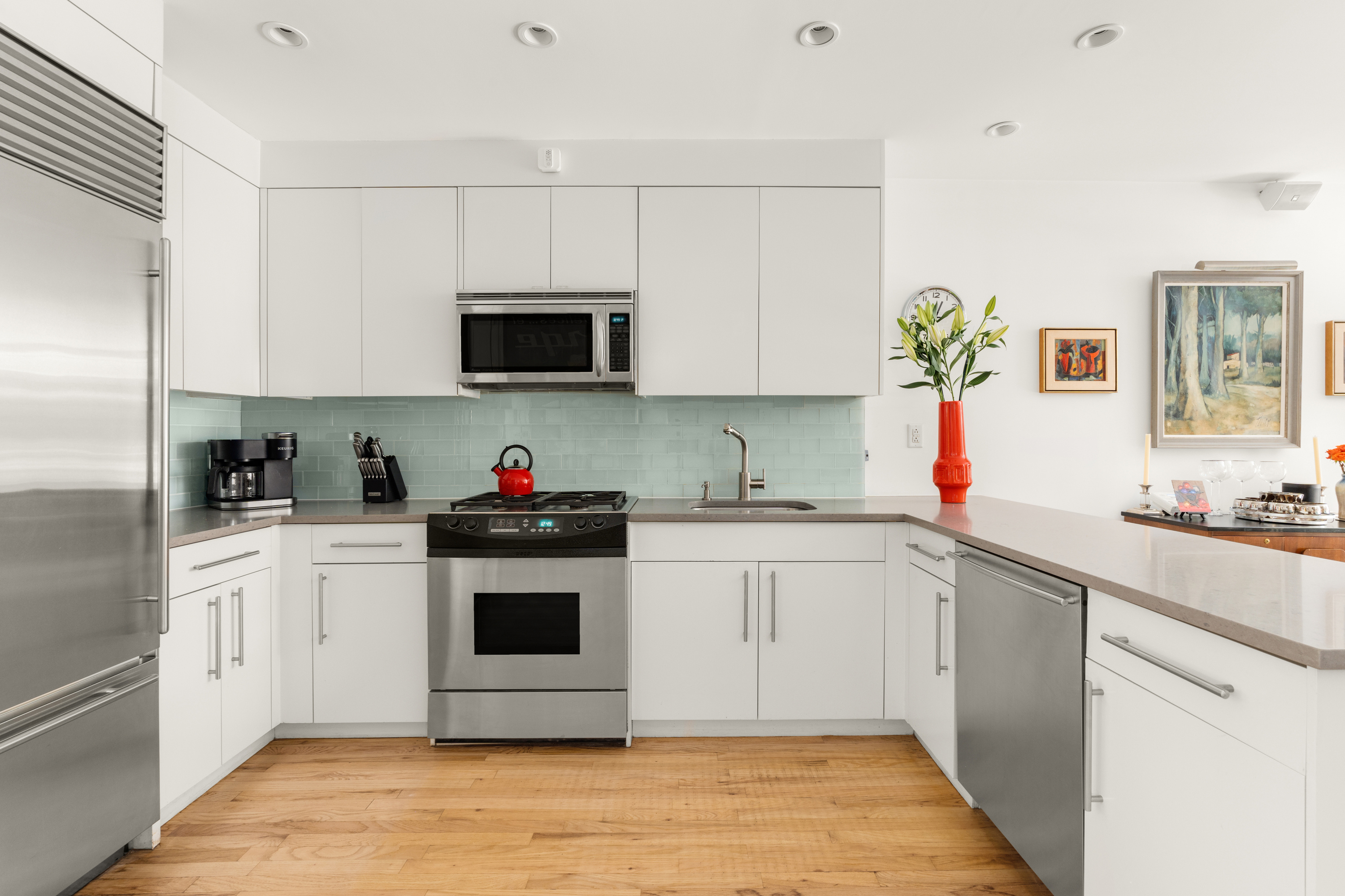 24 West 70th Street, Unit 1 Manhattan, NY 10023 - Photo 12 of 15 a kitchen with stainless steel appliances granite countertop a sink and cabinets