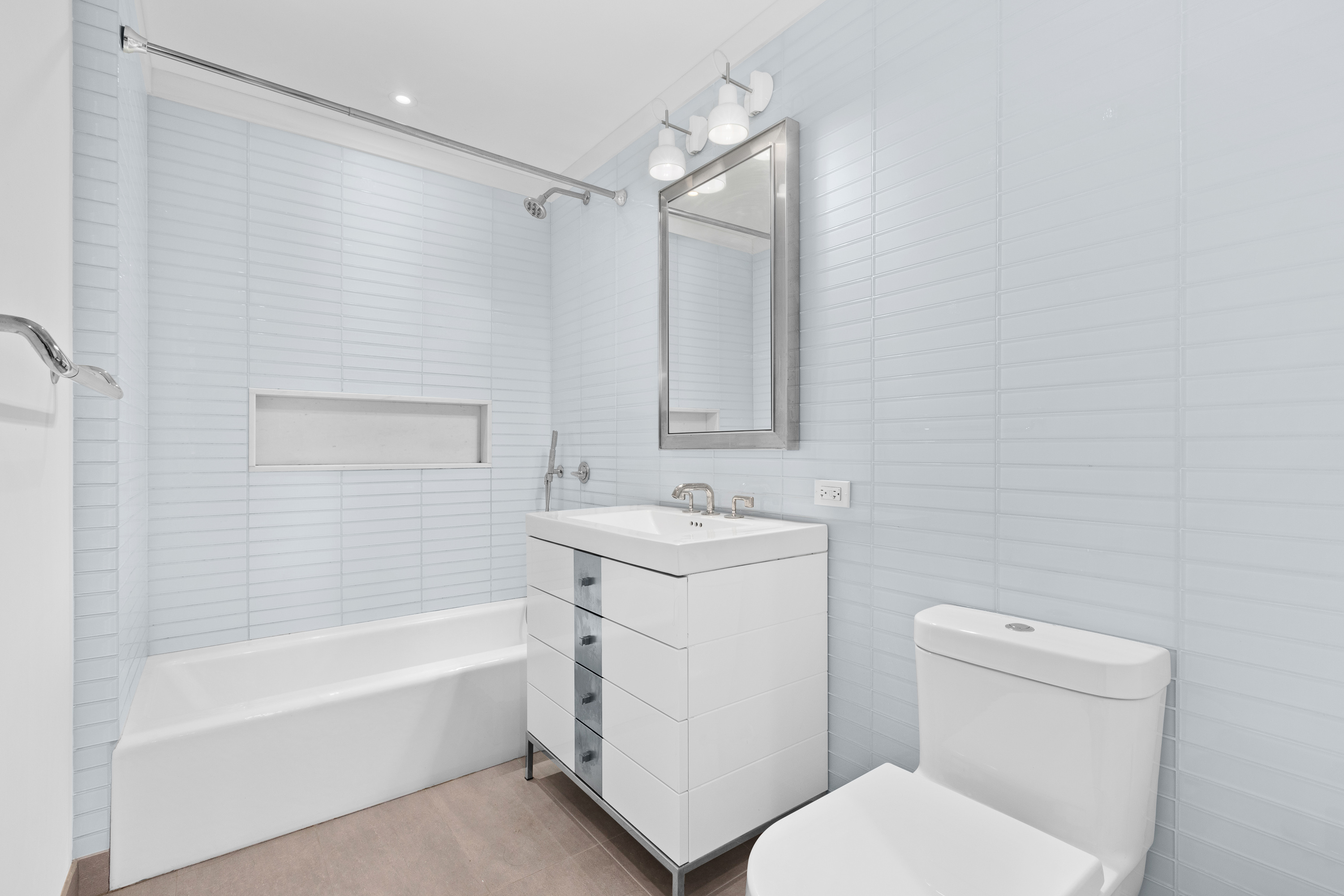 212 Warren Street, Unit 20A Manhattan, NY 10282 - Photo 17 of 23 a bathroom with a sink toilet vanity and bathtub