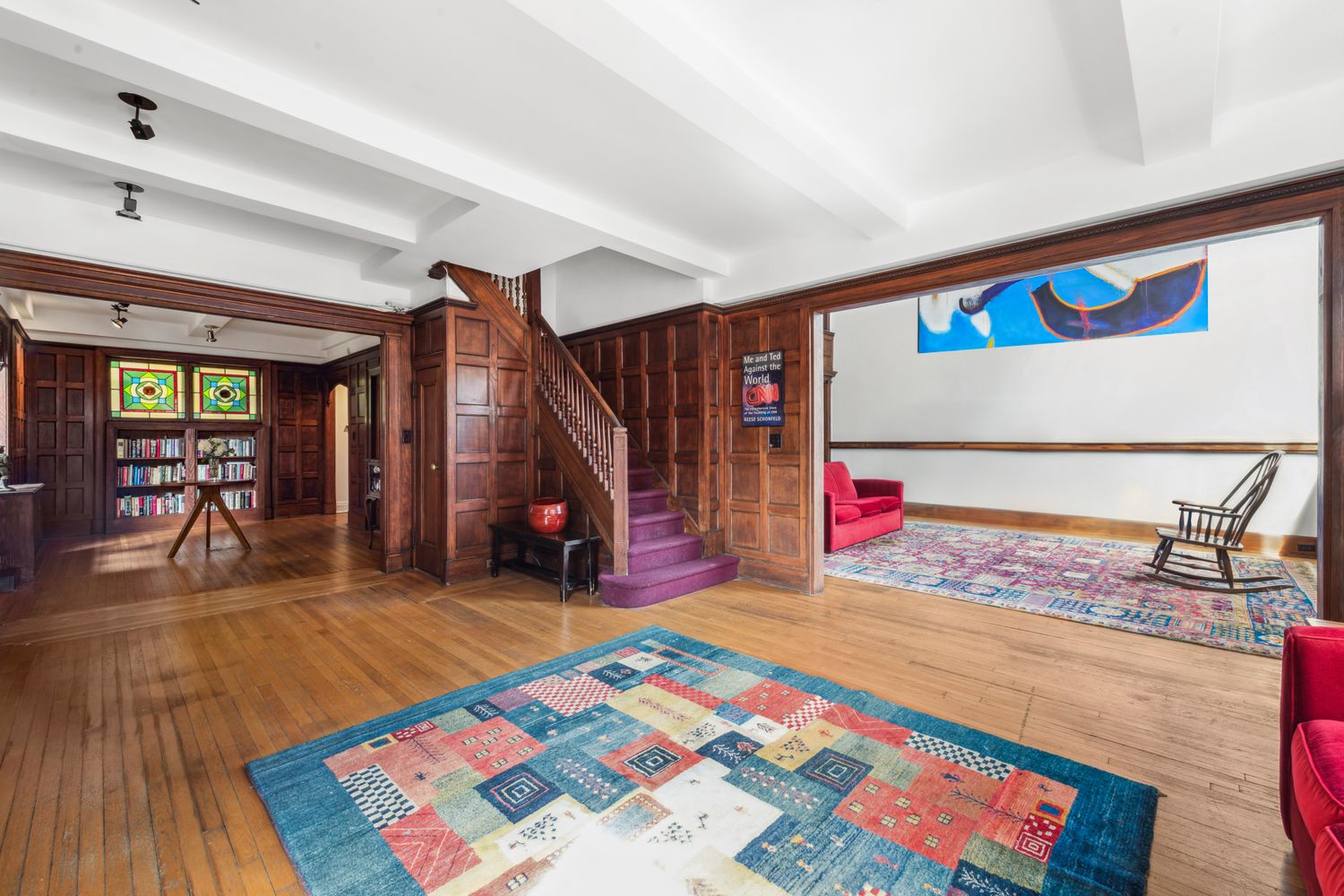 a view of an empty room with wooden floor and stairs