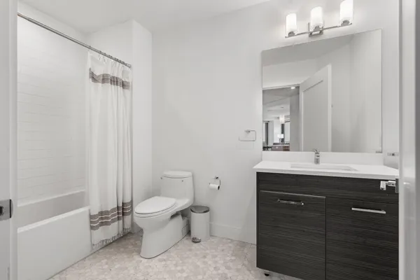 a spacious bathroom with a granite countertop sink a toilet and a mirror