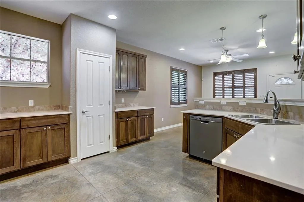 a large kitchen with granite countertop a large counter top space appliances and a window