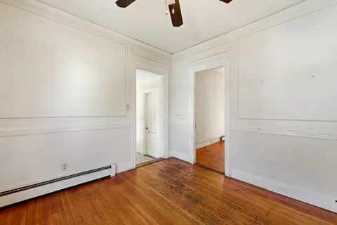 a view of a room with wooden floor and a potted plant