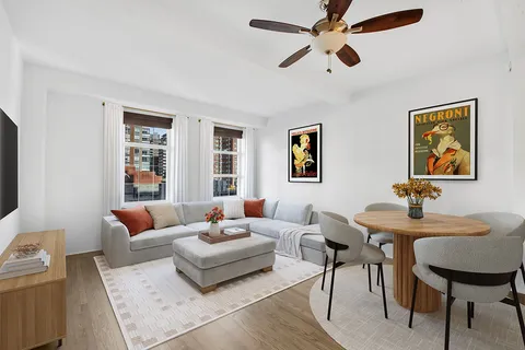 a living room with furniture a chandelier and a window