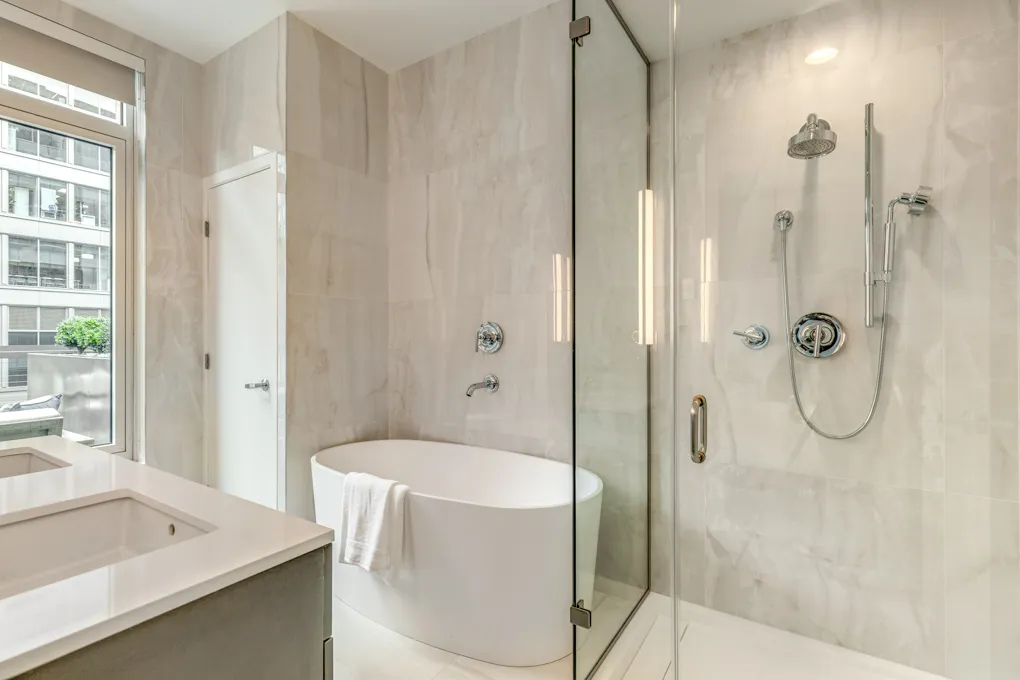 a bathroom with a granite countertop sink a mirror and a shower