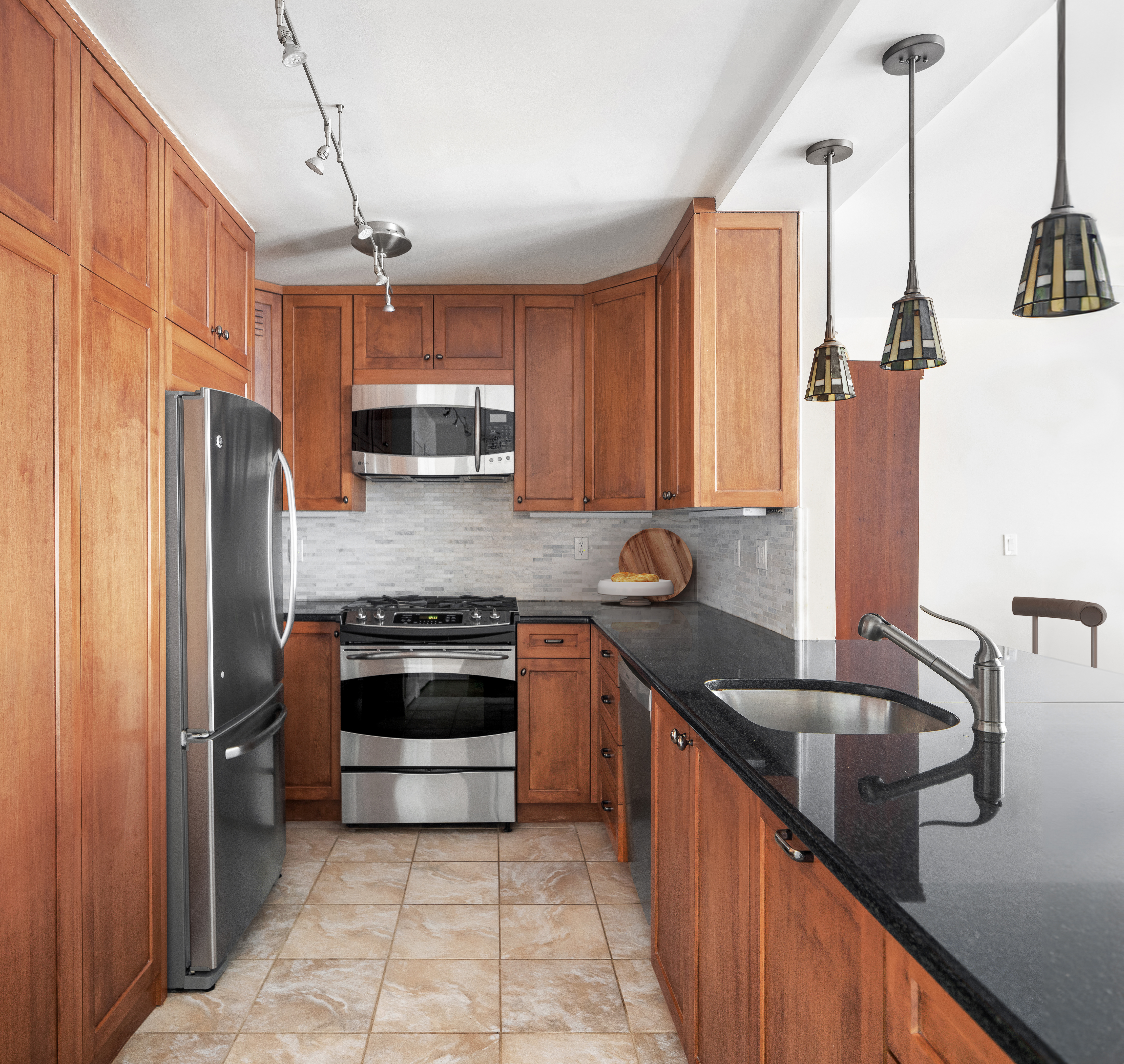 15 West 72nd Street, Unit 8TU Manhattan, NY 10023 - Photo 4 of 12 a kitchen with granite countertop a sink and stainless steel appliances