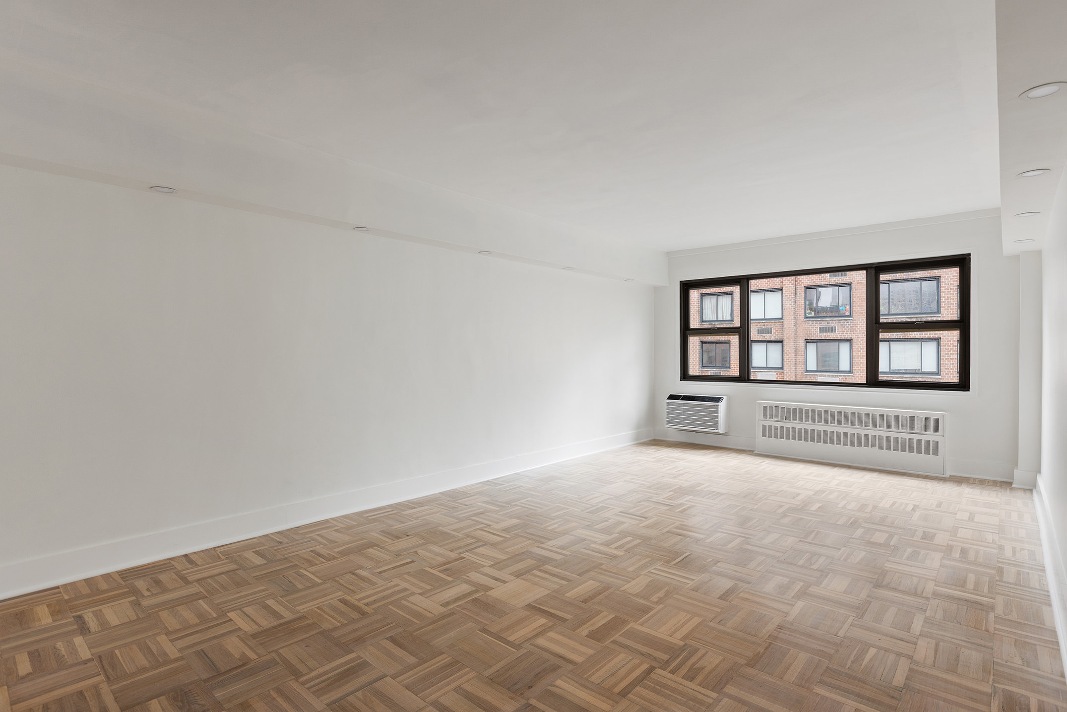 335 East 51st Street, Unit 9D Manhattan, NY 10022 - Photo 2 of 14 wooden floor in an empty room with a window