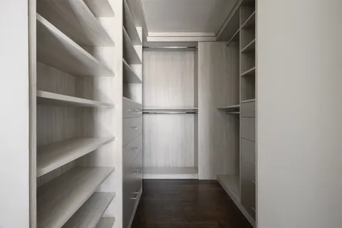 a view of walk in closet with empty racks