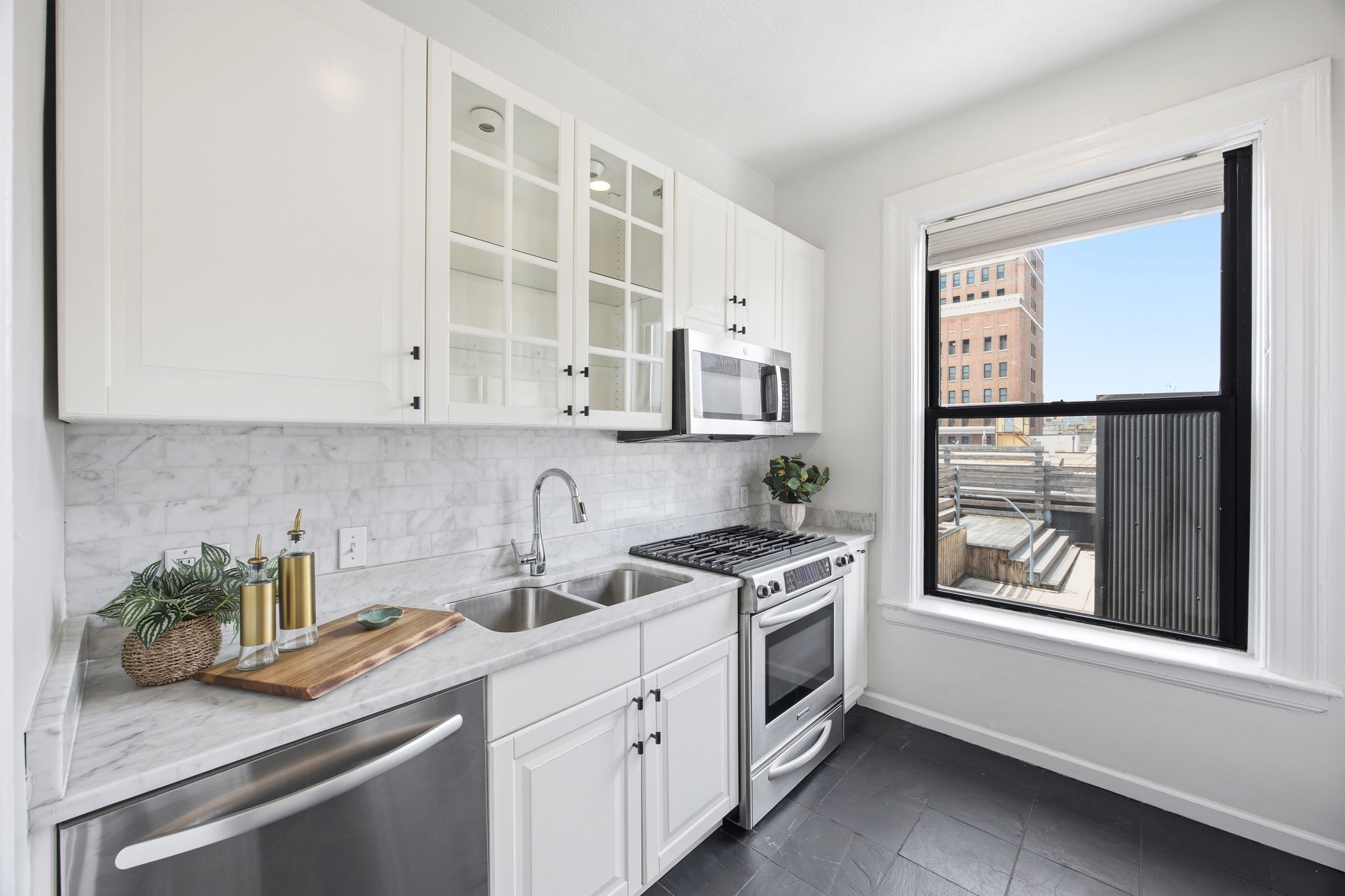 485 Central Park West, Unit 7A Manhattan, NY 10025 - Photo 5 of 15 a kitchen with stainless steel appliances white cabinets and a window