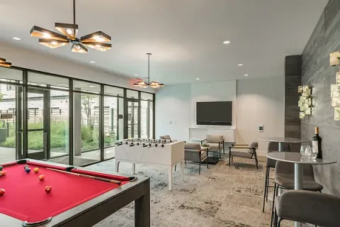 a living room with furniture pool table and a flat screen tv