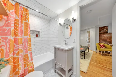 a bathroom with a sink a toilet a mirror and shower