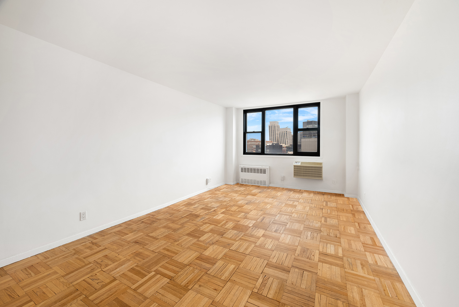 61 Jane Street, Unit 15K Manhattan, NY 10014 - Photo 10 of 16 a big room with wooden floor and a window
