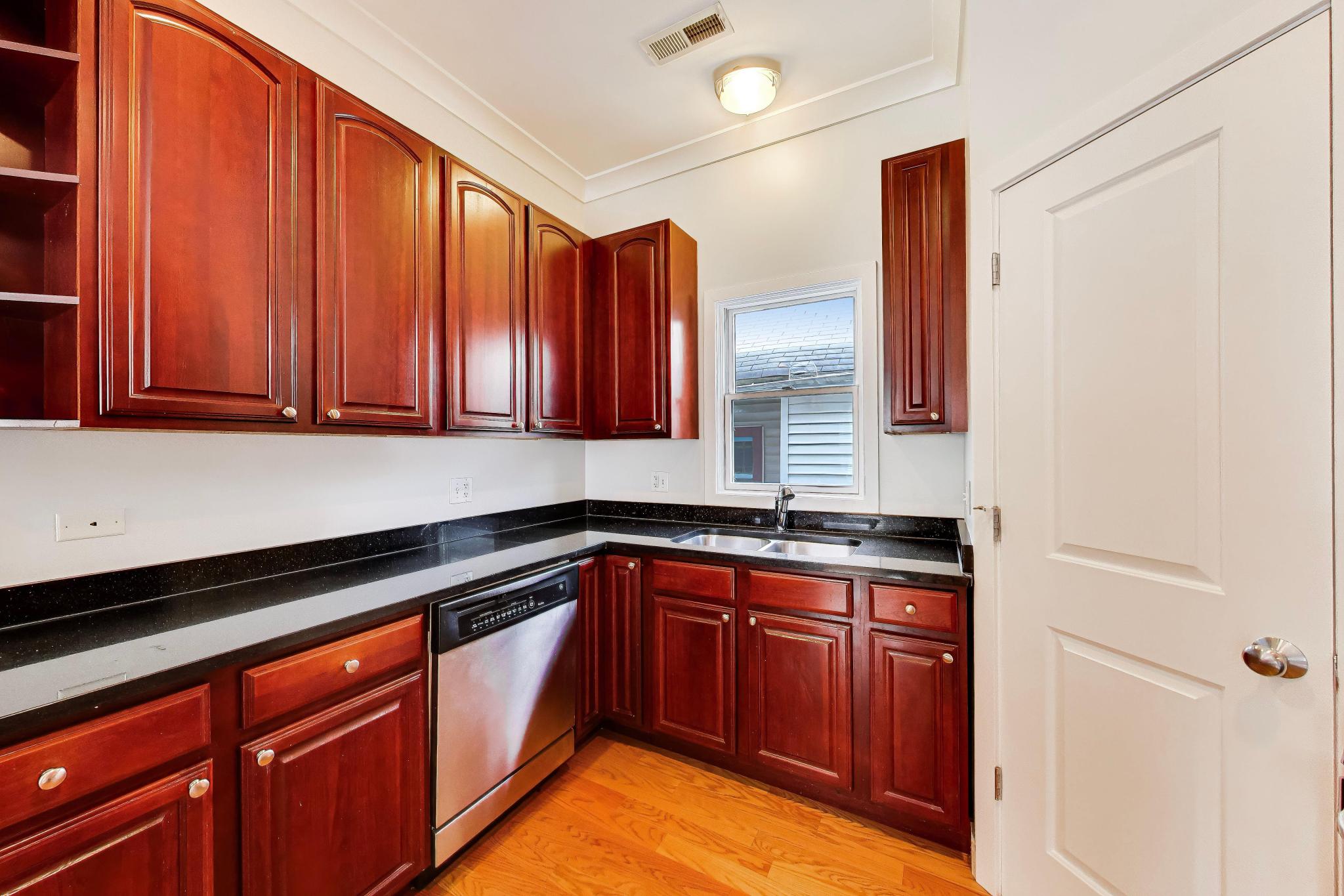 4845 North Springfield Avenue, Unit 2 Chicago, IL 60625 - Photo 12 of 32 a kitchen with stainless steel appliances granite countertop wooden cabinets a sink and dishwasher