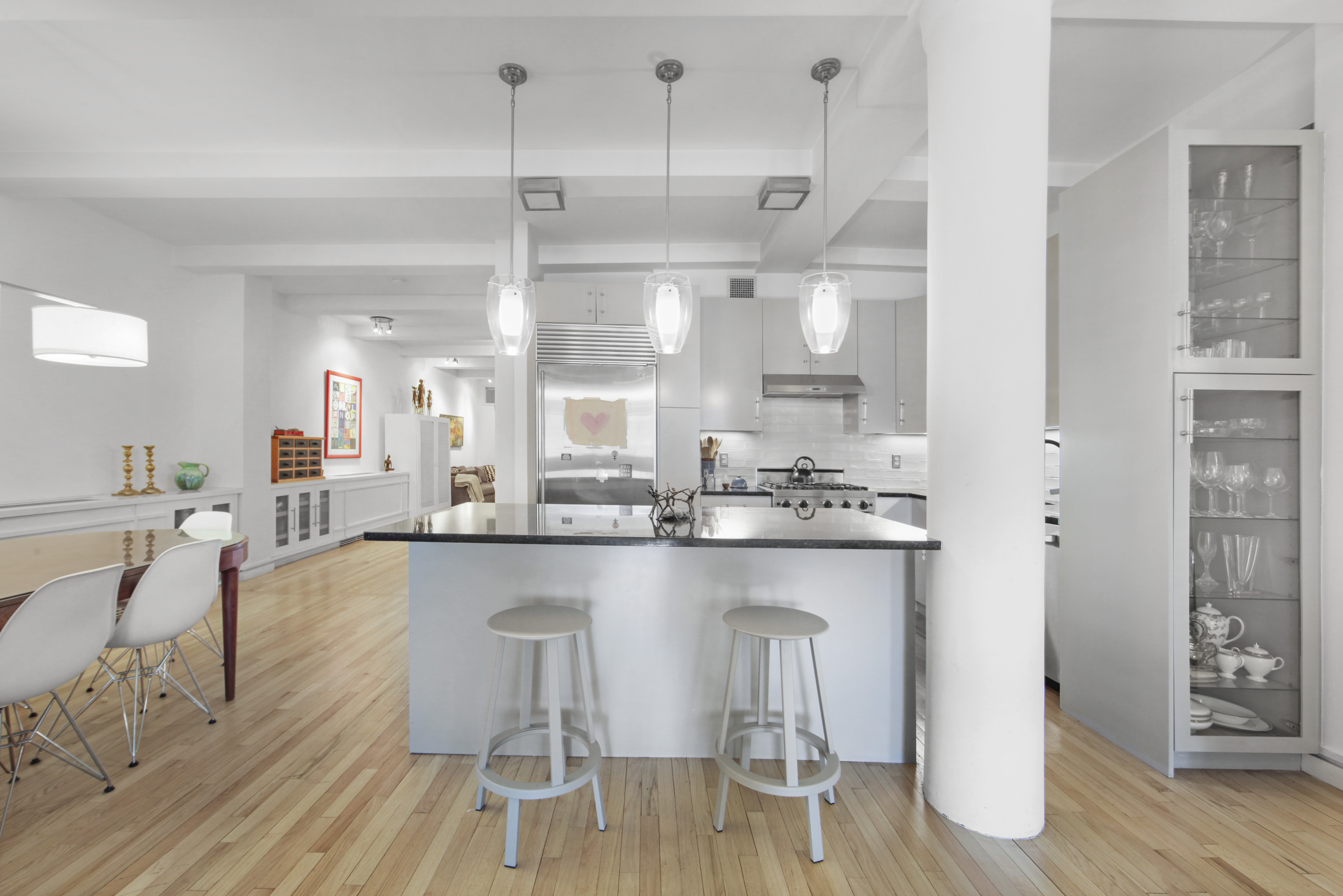 18 East 12th Street, Unit 7BC Manhattan, NY 10003 - Photo 5 of 26 a kitchen with a table chairs refrigerator and cabinets