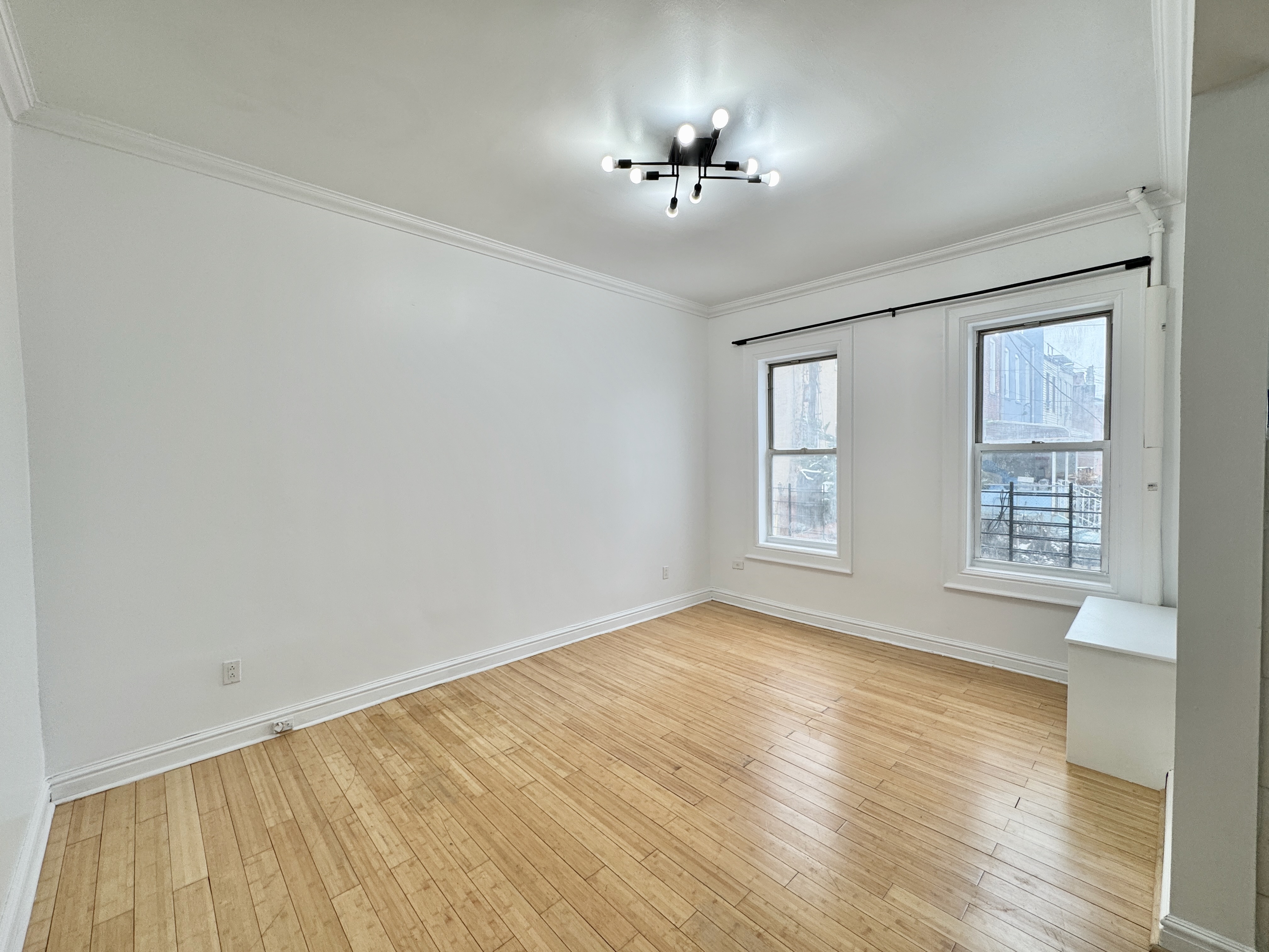 347 Berriman Street, Unit 1 Brooklyn, NY 11208 - Photo 2 of 6 a view of an empty room with a window and wooden floor