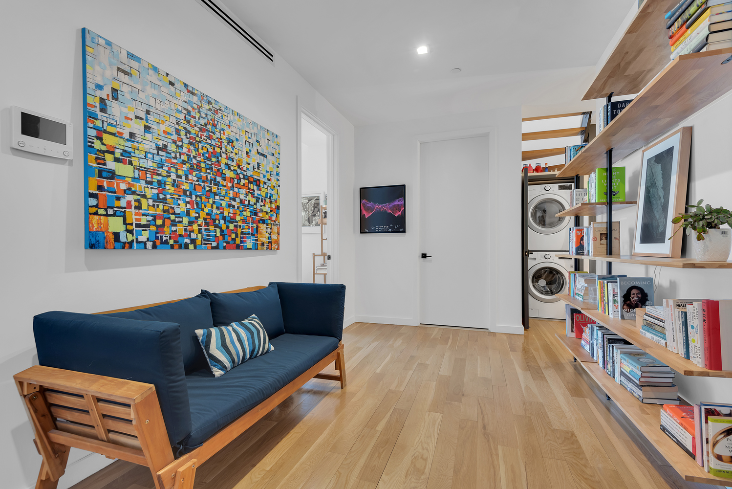 267 Evergreen Avenue, Unit PH Brooklyn, NY 11221 - Photo 9 of 19 a couch sitting in a living room next to a book shelf