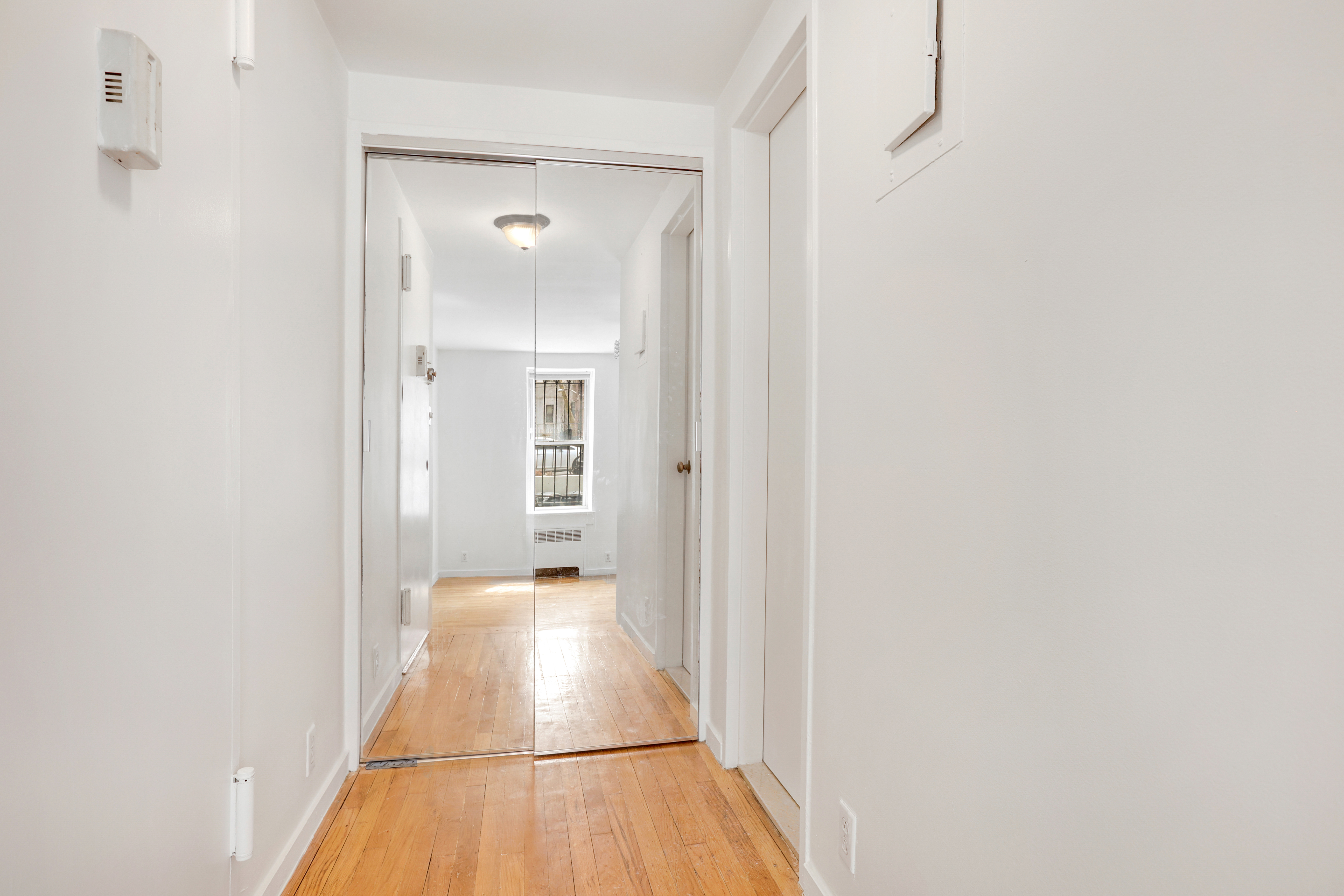 141 West 94th Street, Unit 1F Manhattan, NY 10025 - Photo 6 of 9 a view of a hallway with wooden floor and staircase