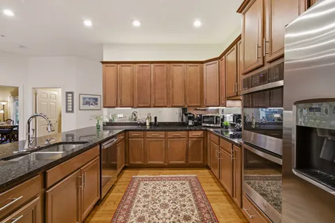 a kitchen with stainless steel appliances granite countertop a refrigerator stove and sink