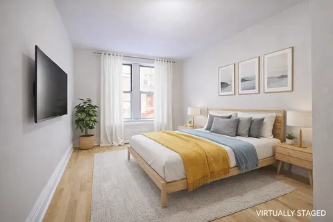 a spacious bedroom with a bed and a flat screen tv