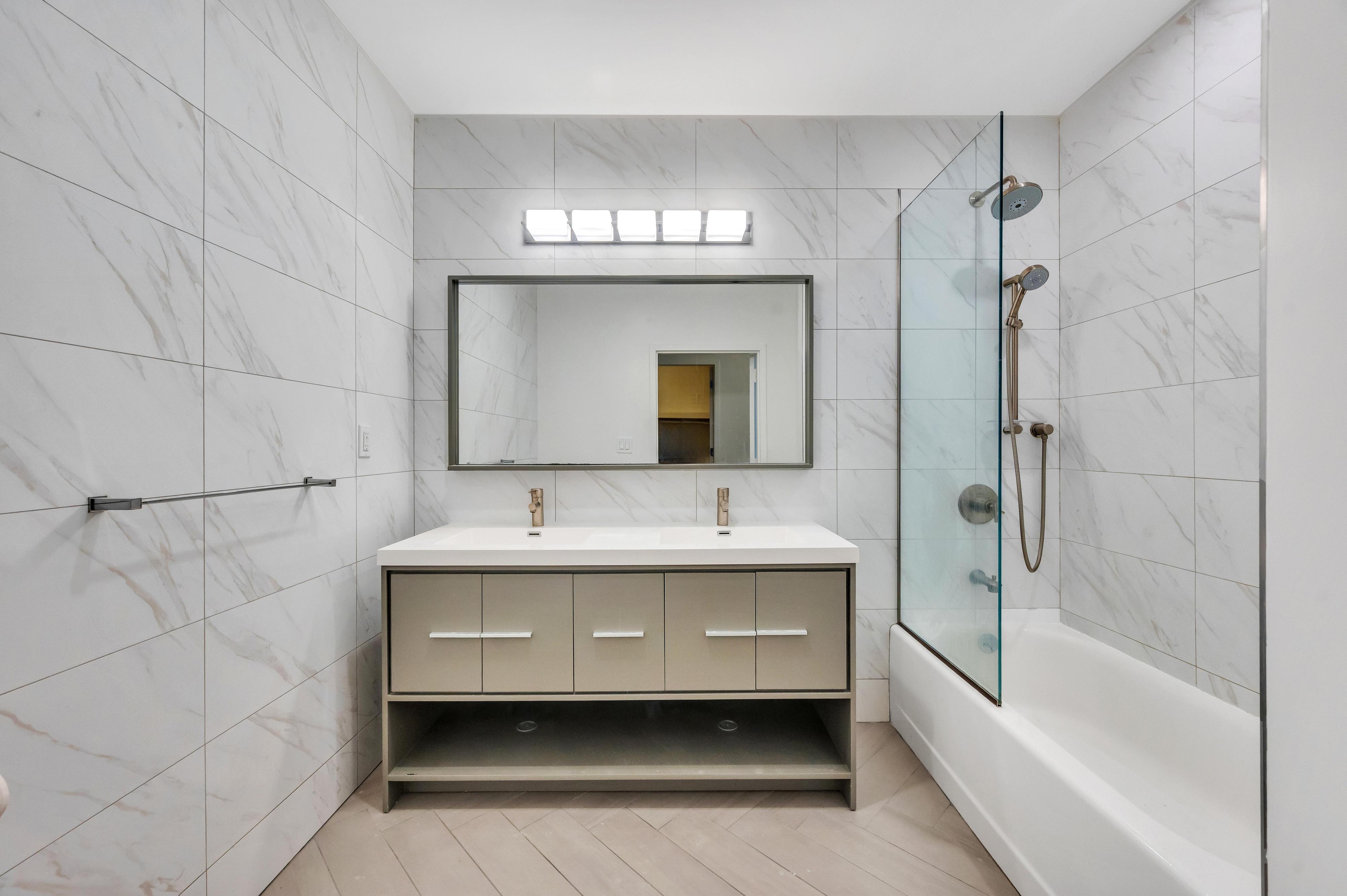 717 Manhattan Avenue, Unit 3A Brooklyn, NY 11222 - Photo 8 of 18 a bathroom with a tub sink and mirror