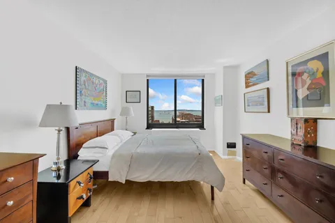 a bedroom with a large bed and a large window with the view of room