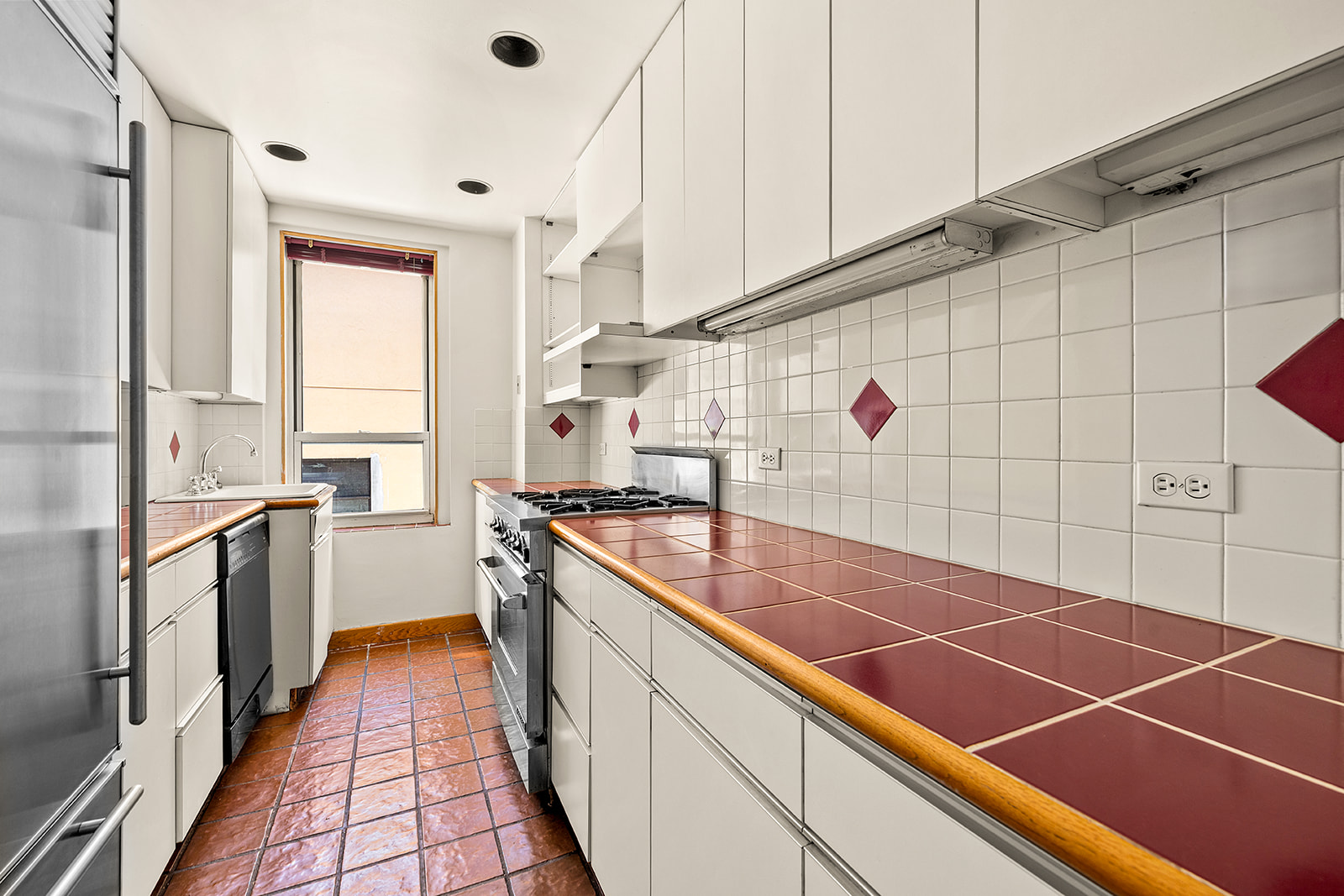 345 West 55th Street, Unit 8AB Manhattan, NY 10019 - Photo 3 of 14 a room with stainless steel appliances lots of counter top space and wooden floor