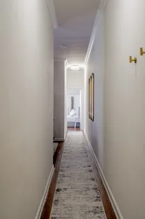 a hallway with wooden floor and closet