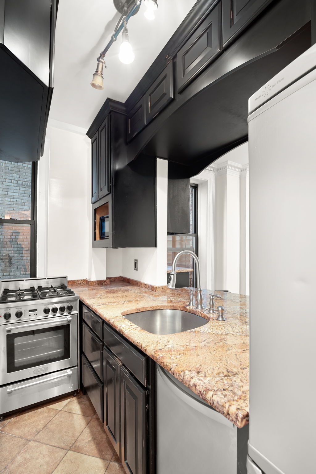 305 West 72nd Street, Unit 7D Manhattan, NY 10023 - Photo 4 of 12 a kitchen with a sink stove and cabinets